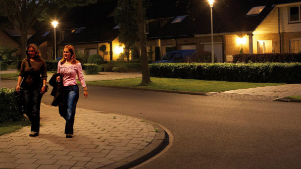 Two women are walking in a street illuminated with Philips white light
