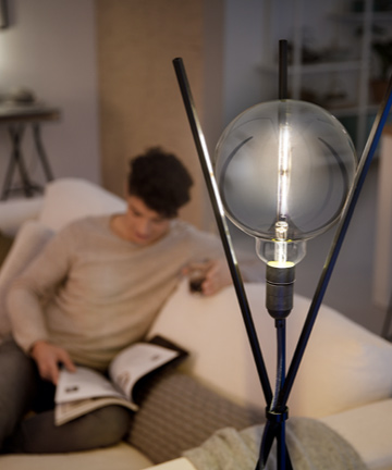 Man reading next to a Philips Modern designed LED bulb 